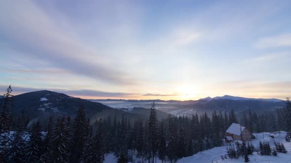 Aerial View of Sunrise in Winter Forest Mountains with Lot of Snow and Snowy Trees in Cold Morning