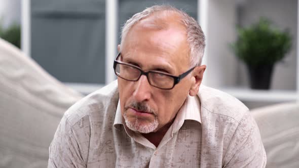 Portrait of Gloomy Mature 70s Gray Haired Man Posing at Home