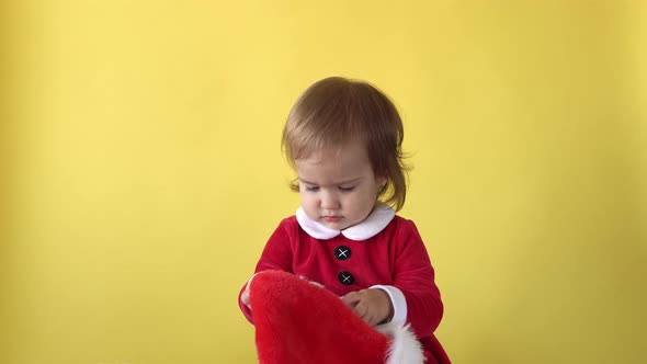 Portrait Emotion Cute Smiling Happy Cheerful Toddler Baby Girl In Santa Suit Looking On Camera At