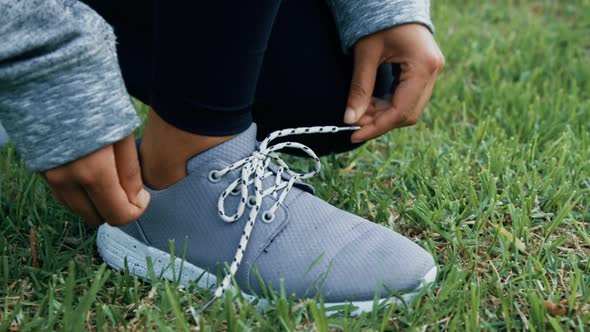 Person tying shoe lace in garden 4k