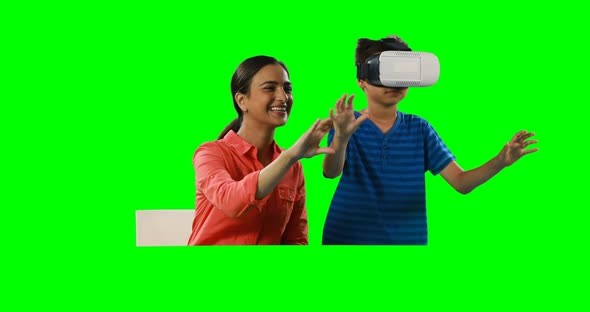 Smiling mother assisting son in using virtual reality headset 4k