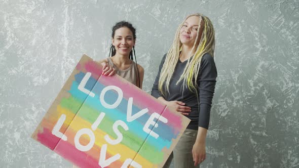 Gay Couple Embracing and Showing Their Love with LGBT Poster