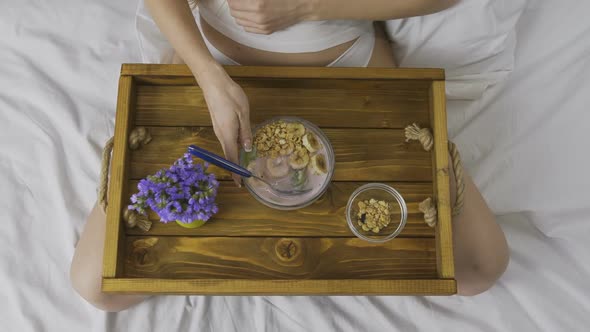 Female Eating Healthy Breakfast in Bed