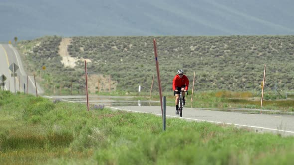 A man road biking on a scenic road.
