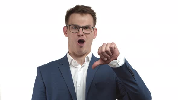 Funny Businessman in Blue Suit and Glasses Showing Thumbsdown and Grimacing Shaking Head As