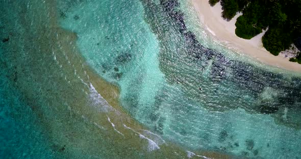 Luxury fly over tourism shot of a sandy white paradise beach and aqua blue ocean background in vibra