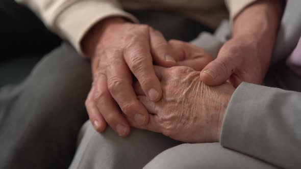 Hand of an Elderly Woman Holding the Hand of an Elderly Man