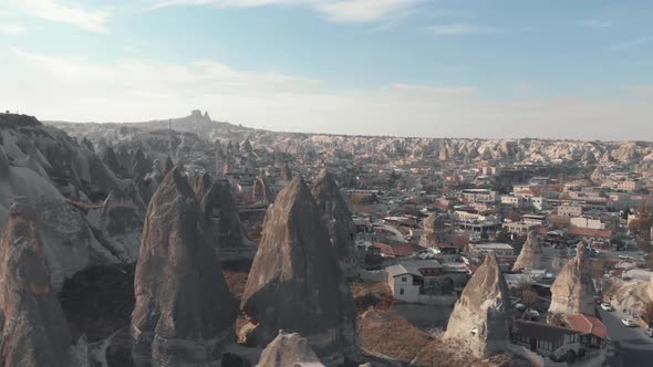 Fairy chimney rock formations in Goreme village, Cappadocia Turkey - Low angle orbit aerial