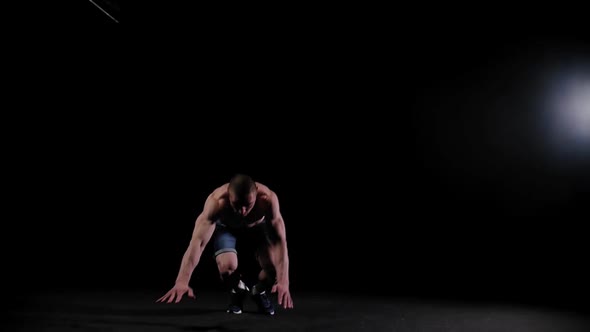 Young Pumped Man Training His Hands in the Dark Arena  Doing Back Flip and a Push Up