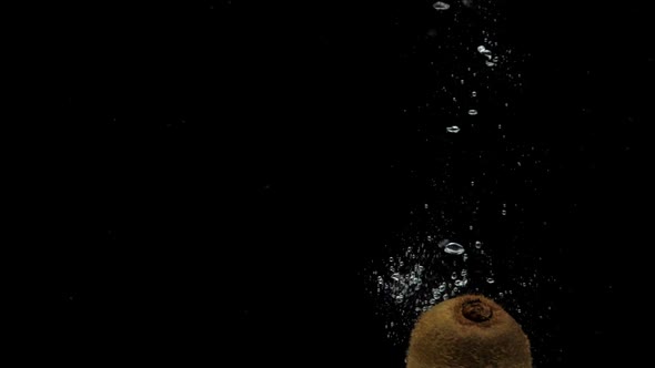 Slow Motion One Kiwi Spinning Falling Into Transparent Water on Black Background