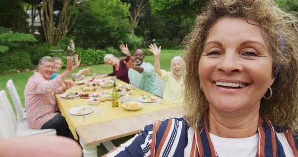 Animation of happy biracial senior woman having video call while eating lunch with friends