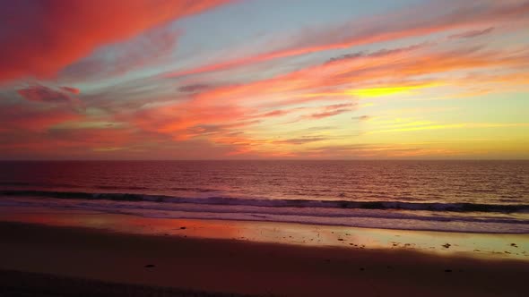 Aerial drone view of a sunset at the beach over the ocean.