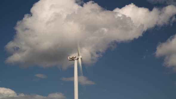 Wind Turbine Close-up with a White Cloud in the Blades Time Lapse