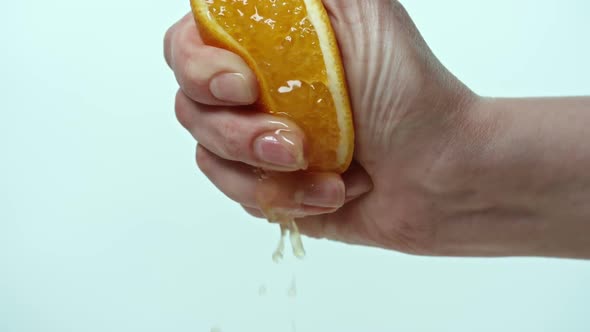 Female hand squeezing orange