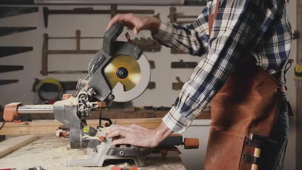 Carpenter Using an Electric Circular Saw Cutting Piece of Wood