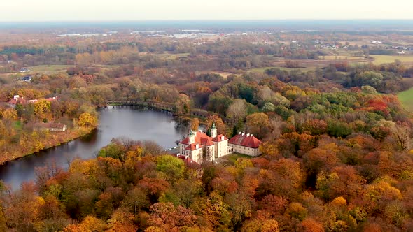 Scenic aerial flight over mist above forrest lake at sunrise, 4K footage. Colorful autumn trees at e