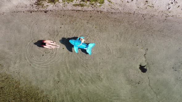 Mother and daughter playing at the waters edge on Agnavika beach in Stanghelle Norway - Summer vacat