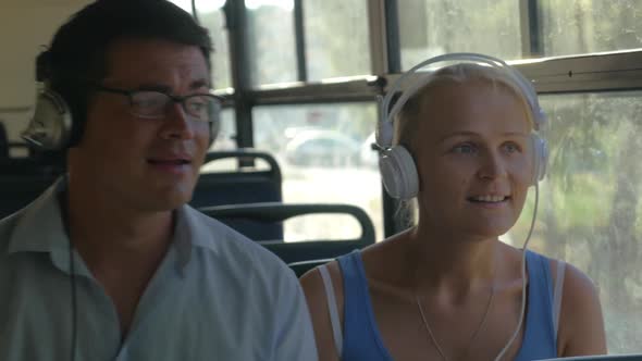 Young Couple Listening To Music on Headphones During the Bus Ride, They Dance To the Music, Man