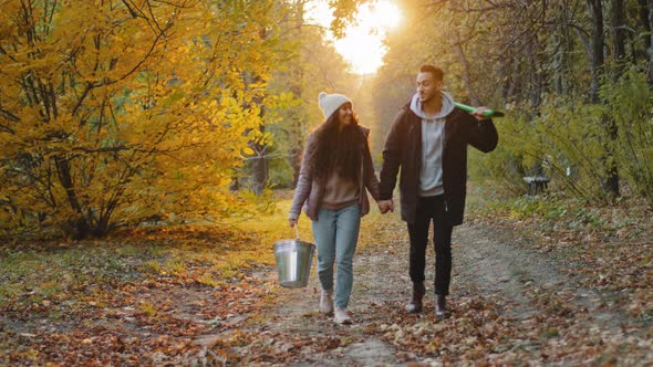 Young Happy Couple in Love Students Volunteers Eco Activists Walking in Autumn Park at Sunset in Sun