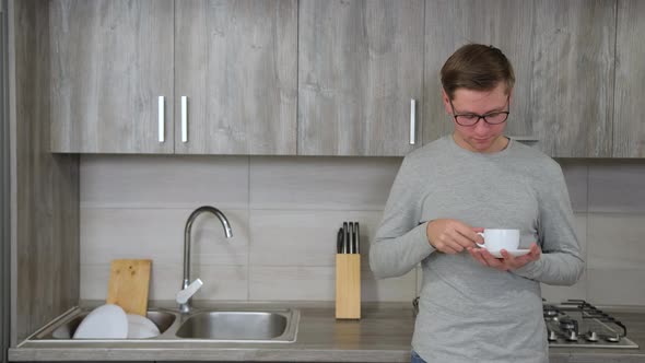 Guy Is Drinking Hot Strong Coffee From a White Cup While Take a Break From Work.