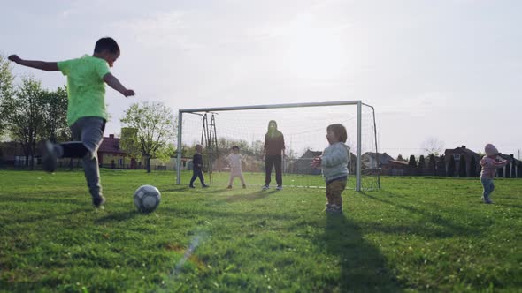 Family Playing Soccer on the Grass