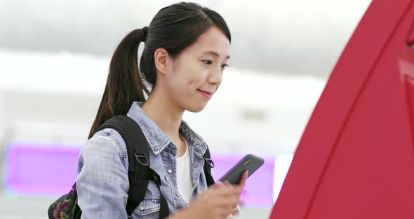 Asian Woman using selfie check in machine in the airport 