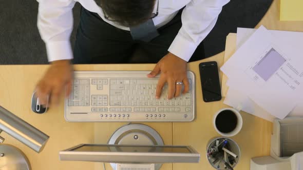 Timelapse overhead shot of businessman working at office desk