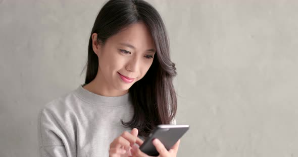 Woman use of smart phone over grey background