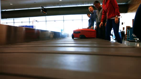 Commuters taking their baggage from baggage carousel