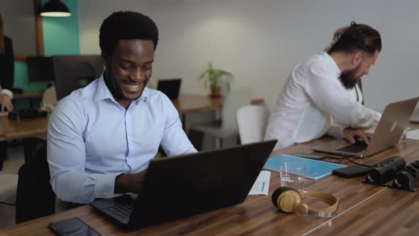 Happy young African man working inside modern office - Entrepreneurship concept