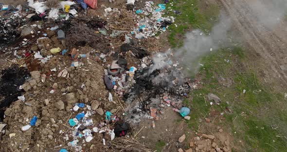 Pile of trash on the side of the road burning