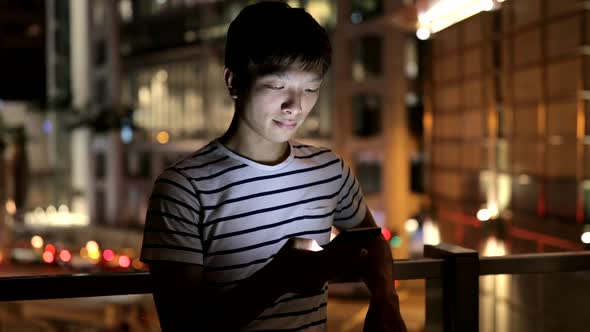 Young man use of mobile phone in the city 