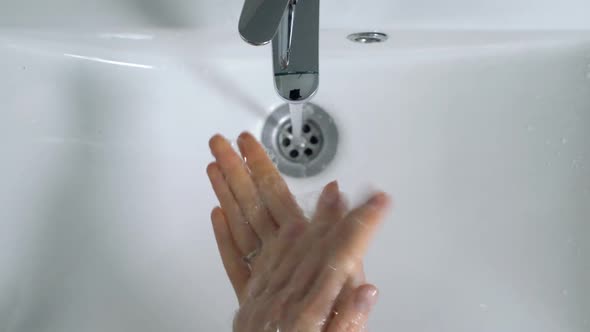 Young Woman Washing Hands in Bathroom at Home