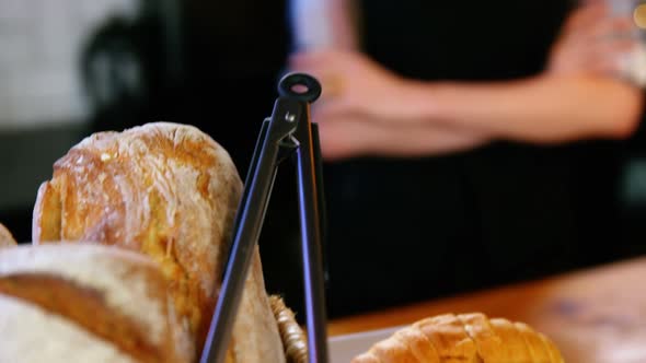 Portrait of waitress standing at counter with bread loaf