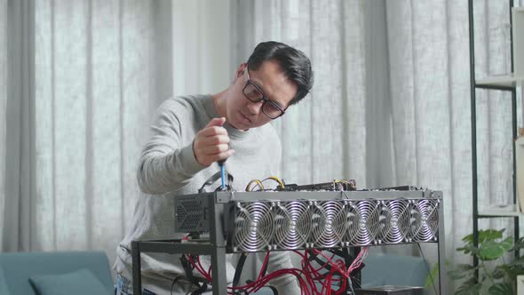 Asian Man Wearing Glasses Cleans The Mining Rig For Mining Cryptocurrency