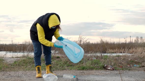 woman collects plastic bottles, the concept of ecology of the earth