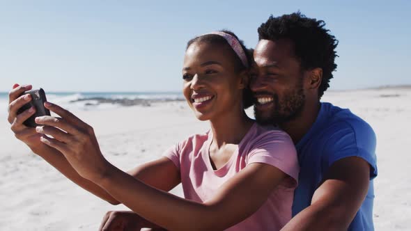 African american couple smiling taking selfie with smartphone on the beach