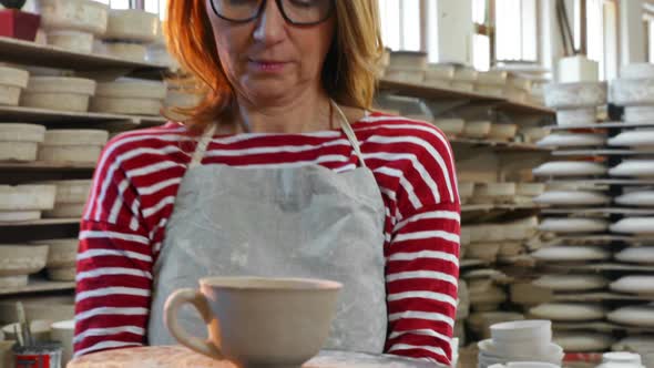 Female potter holding cup