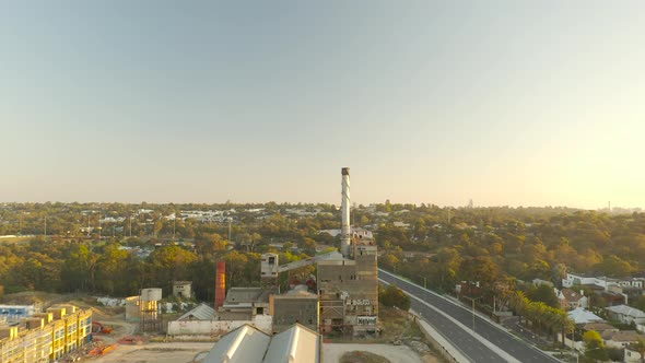 Drone ascent directly straight up above construction site at Yarra Bend where historic factory stand