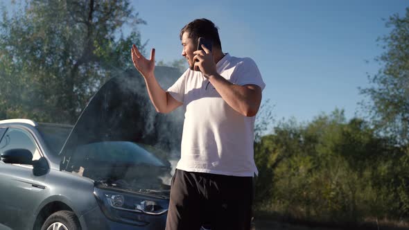 Man Calling Car Assistance Services Because His Car is Broken and There is Smoke