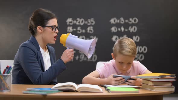 Schoolboy Playing Game on Phone, Teacher Shouting in Megaphone, Naughtiness