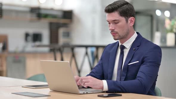 Focused Businessman Working on Laptop in Office