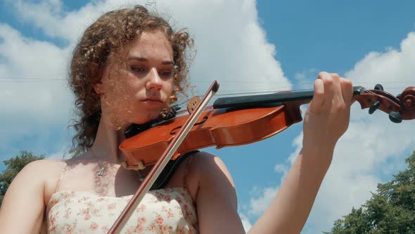 young curly blond woman the violinist: Musician playing violin