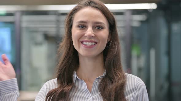 Portrait of Young Businesswoman Waving, Welcoming