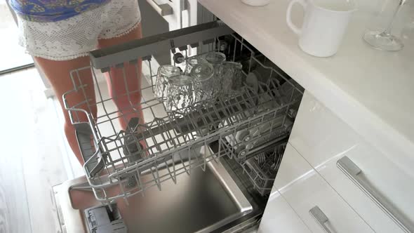 Woman Loading Glasses and Glassware To Dishwasher Machine