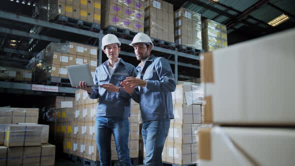 engineer staff male warehouse worker in hard hat working. walking through logistics center warehouse