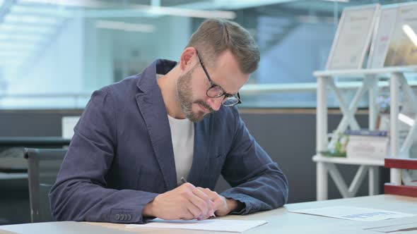 Middle Aged Businessman Having Failure While Writing on Paper