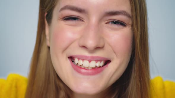 Closeup Positive Woman Making Funny Faces with Orange in Hands in Studio