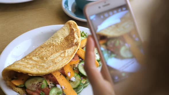 Hands Taking Picture of Healthy Organic Breakfast Served on White Plate. Omelette with Vegetables. 