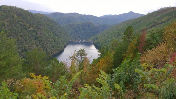 A dam and lake surrounded by the Great Smoky Mountains National Park with scenic autumn trees Calder